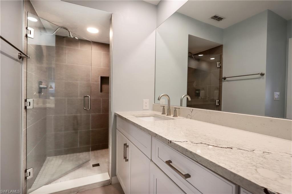 Bathroom with vanity, a shower stall, and recessed lighting