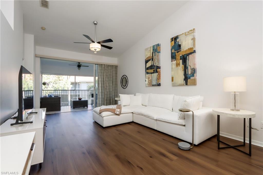 Living area with dark wood-style flooring and ceiling fan