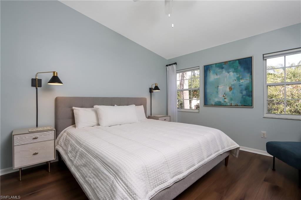 Bedroom with wood finished floors, lofted ceiling, and a ceiling fan