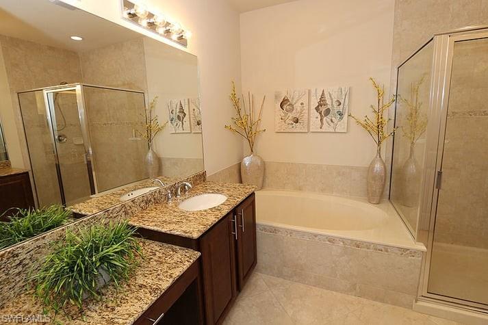 Bathroom with vanity, plus walk in shower, and tile patterned flooring