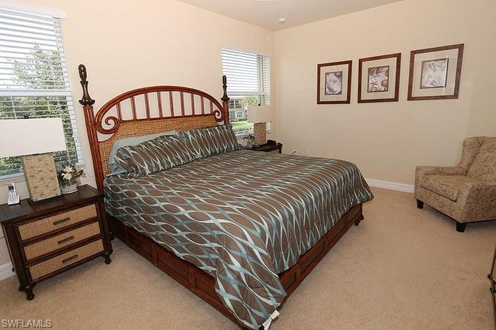 Bedroom with light carpet and multiple windows