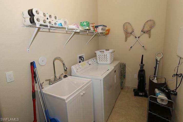 Clothes washing area featuring light tile patterned flooring and independent washer and dryer