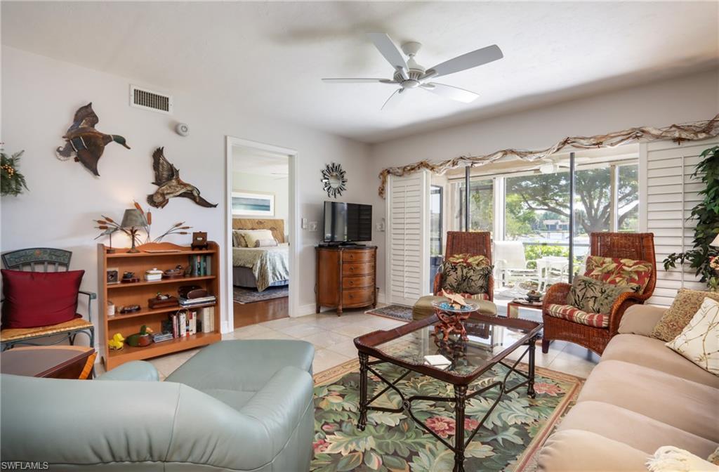 Living room with a ceiling fan and light tile patterned flooring