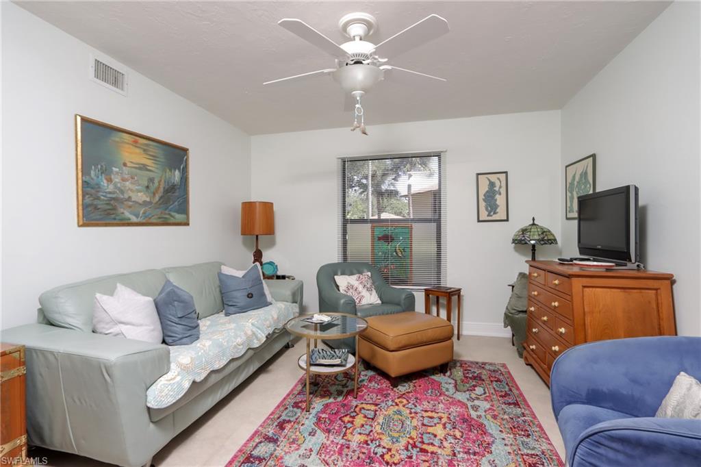 Living room featuring ceiling fan and light carpet