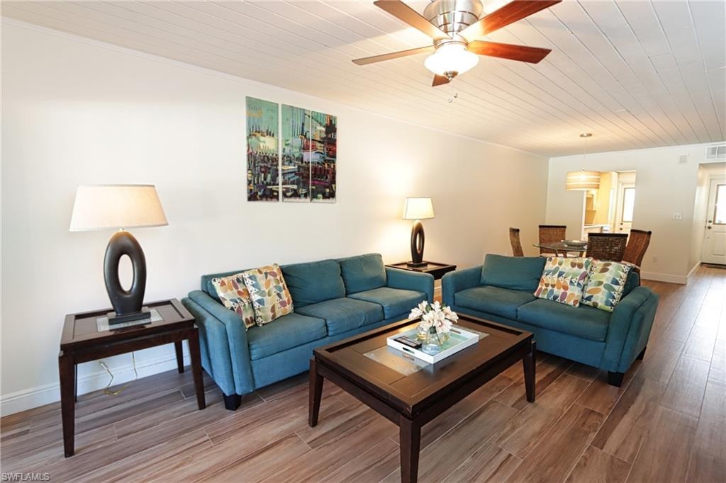 Living room with ceiling fan, crown molding, wooden ceiling, and hardwood / wood-style flooring