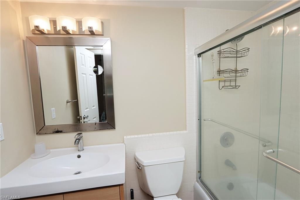 Bathroom with vanity, tile walls, and toilet