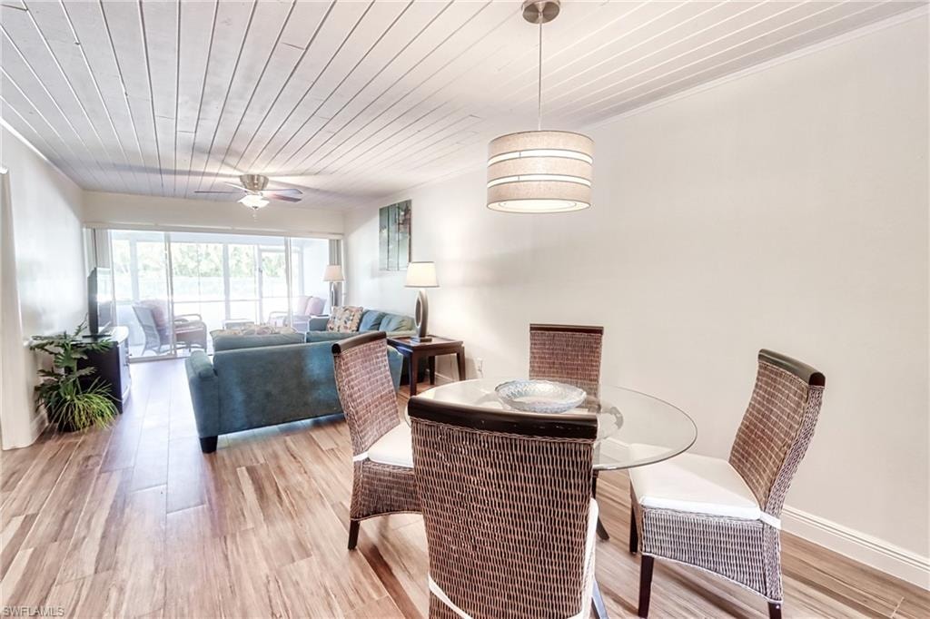 Dining area featuring wood ceiling, ceiling fan, hardwood / wood-style flooring, and ornamental molding