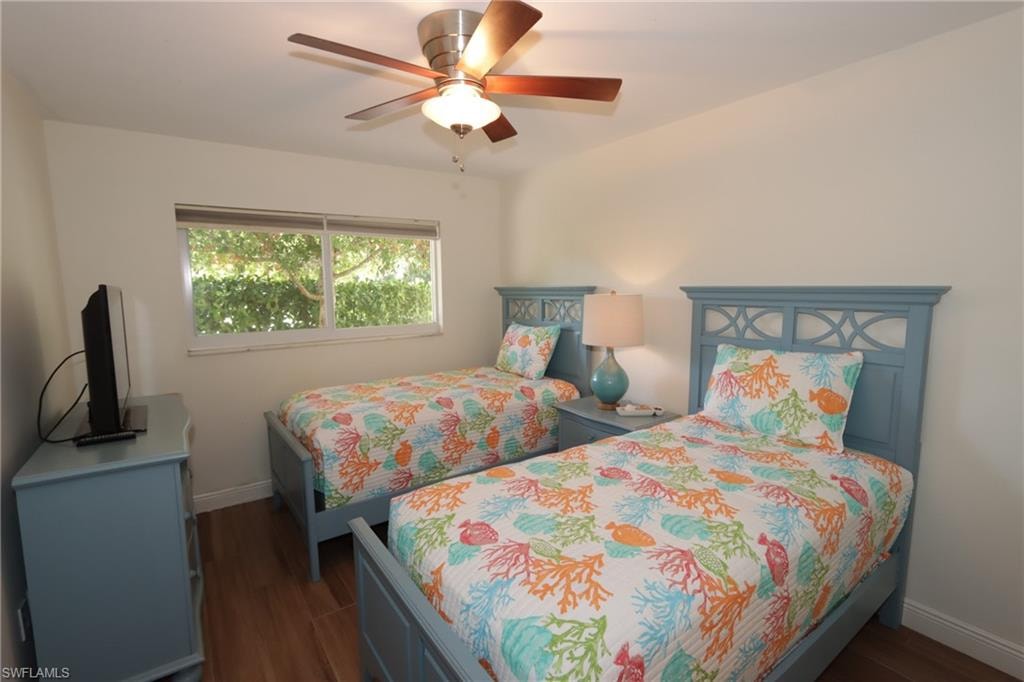 Bedroom with dark wood-type flooring and ceiling fan