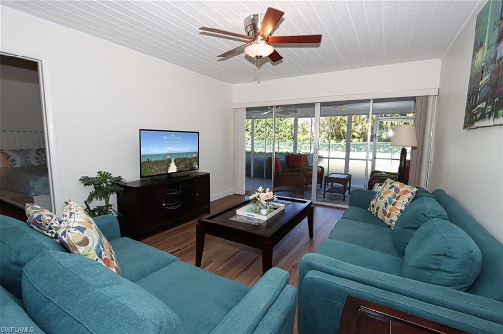Living room featuring crown molding, hardwood / wood-style flooring, ceiling fan, and wooden ceiling