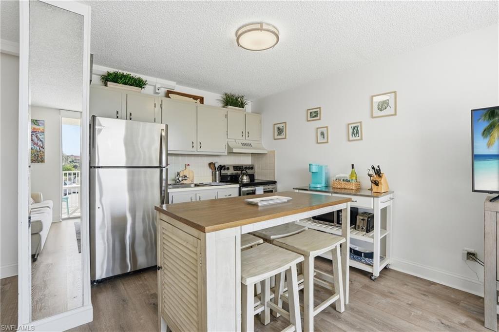 Modern kitchen with a built-in island and light wood-finish countertop - Virtually Edited Image