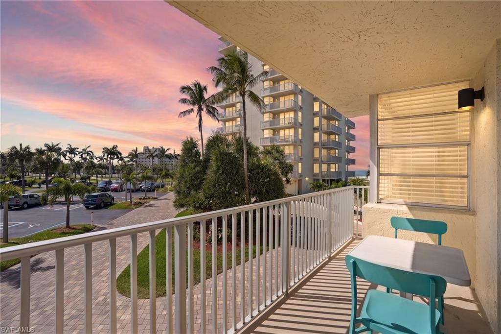 Private balcony featuring a white railing, exterior wall light fixture, and textured ceiling - Virtually Edited Image