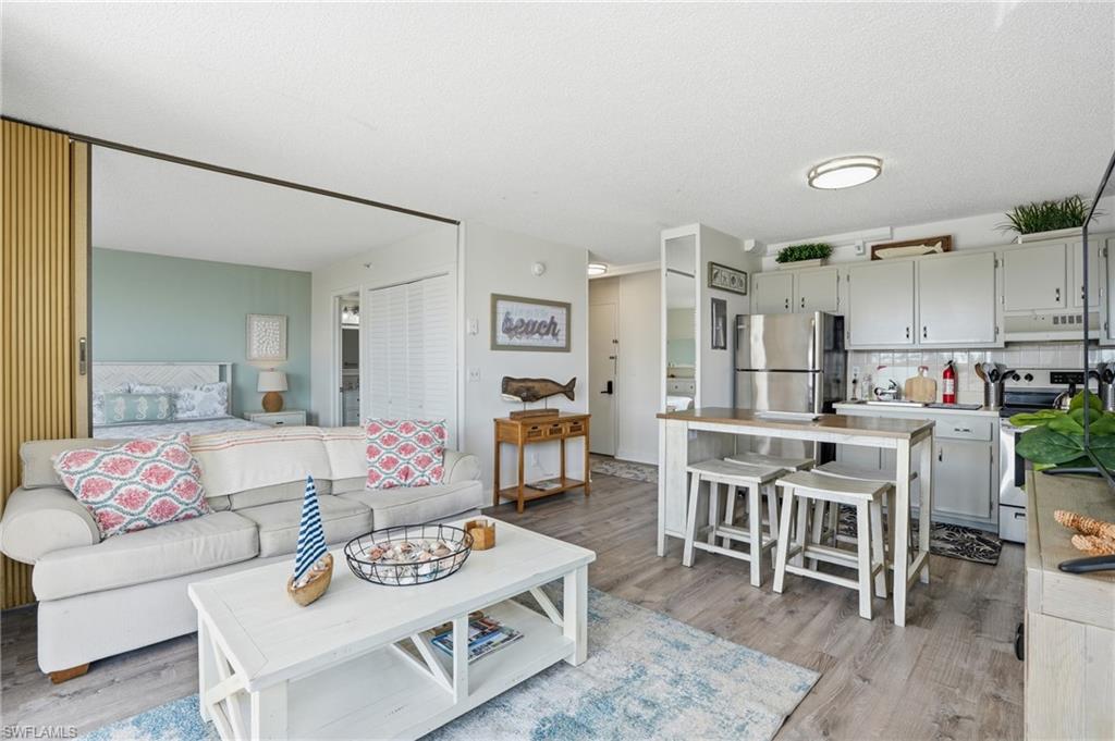 Open-concept living area featuring wood-finish flooring - Virtually Edited Image