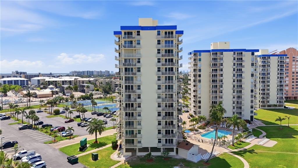 High-rise residential building featuring multiple balconies and a prominent blue roofline - Virtually Edited Image