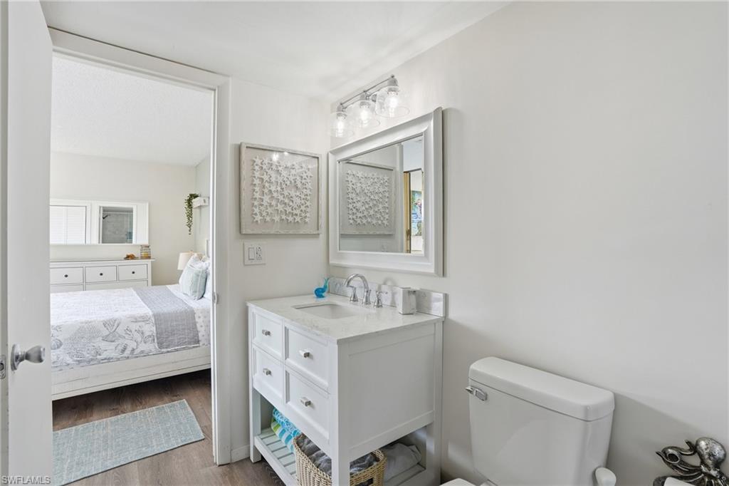 White vanity with integrated sink, chrome faucet, and framed mirror - Virtually Edited Image