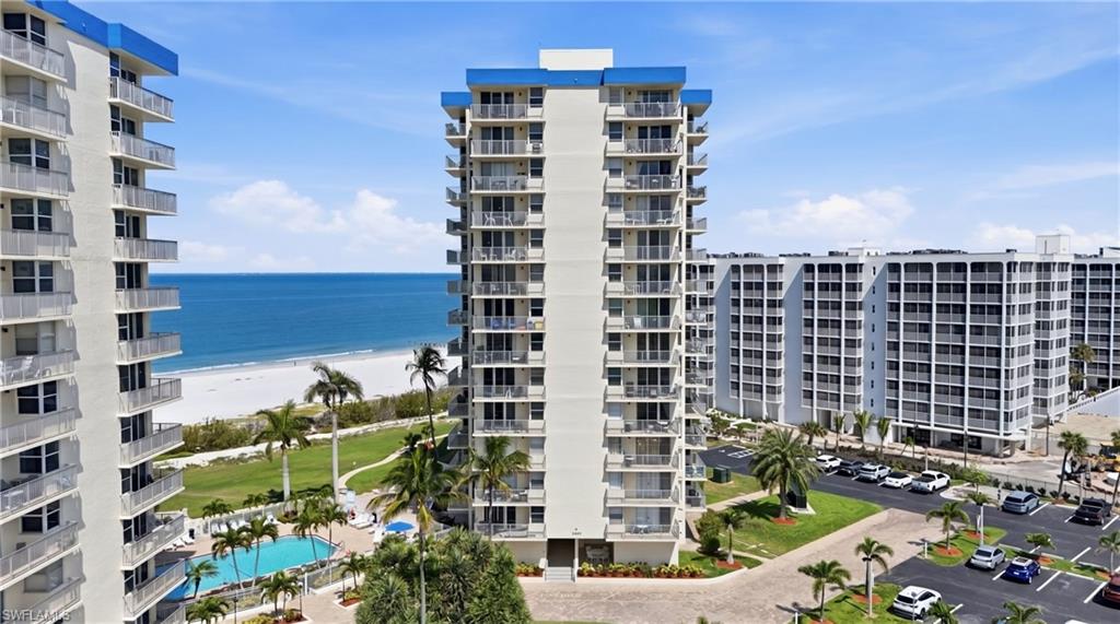 Mid-rise condominium complex with multiple balconies and a blue roofline - Virtually Edited Image