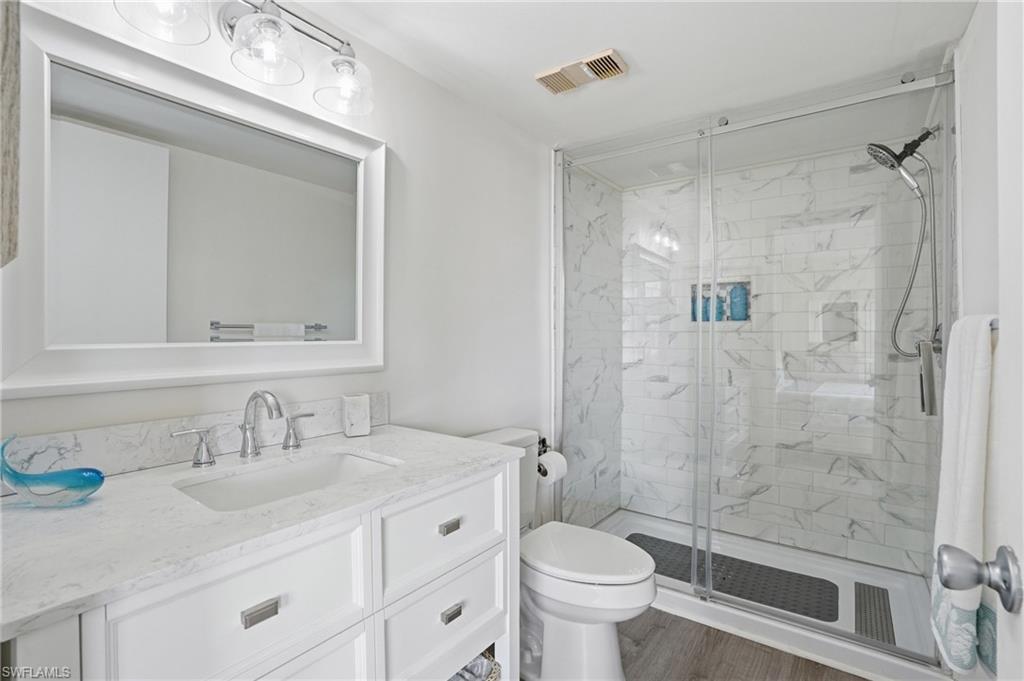 Modern bathroom featuring a white vanity with an integrated sink, a large framed mirror, and chrome fixtures - Virtually Edited Image