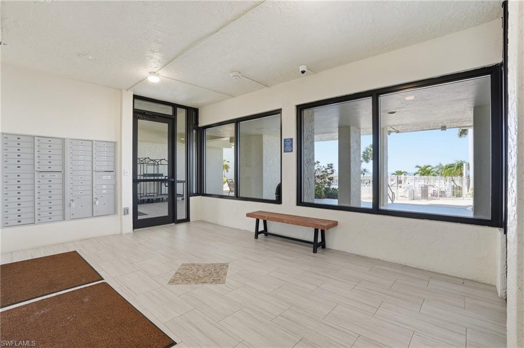 Bright entryway featuring light-toned tile flooring with a decorative inlay - Virtually Edited Image