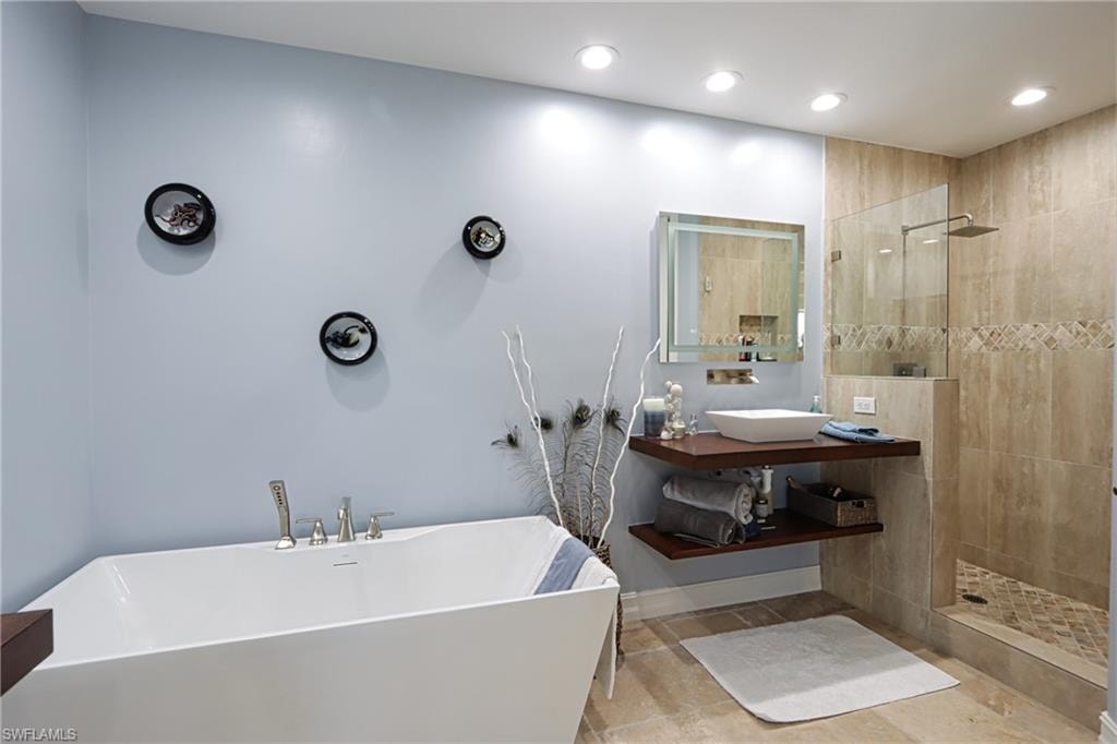 Bathroom with vanity, tile patterned floors, and separate shower and tub