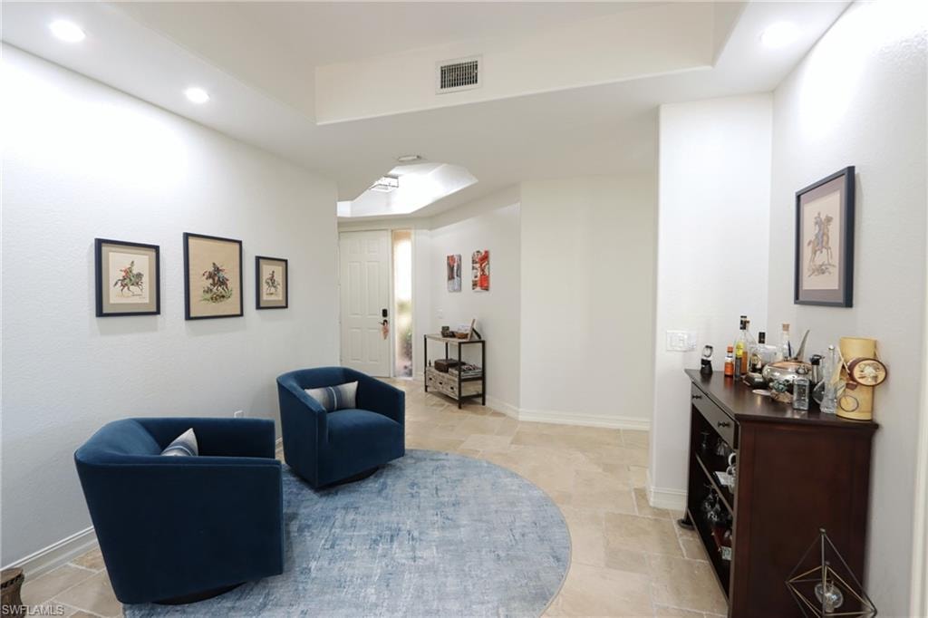 Living area featuring light tile patterned flooring and a tray ceiling