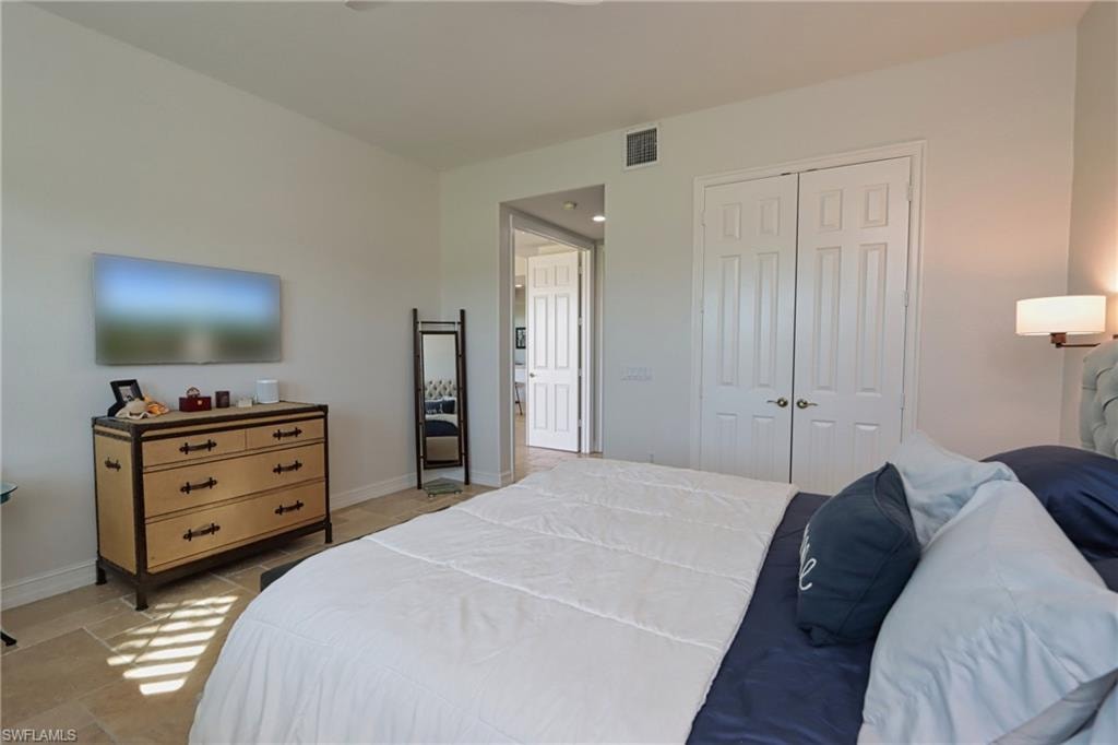 Tiled bedroom featuring a closet