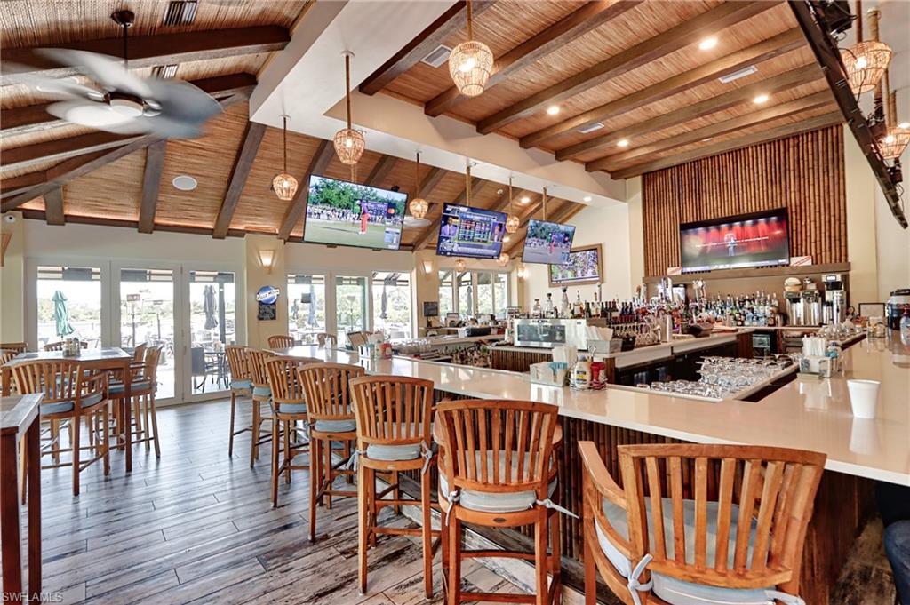 Bar with hanging light fixtures, beamed ceiling, plenty of natural light, and wood ceiling