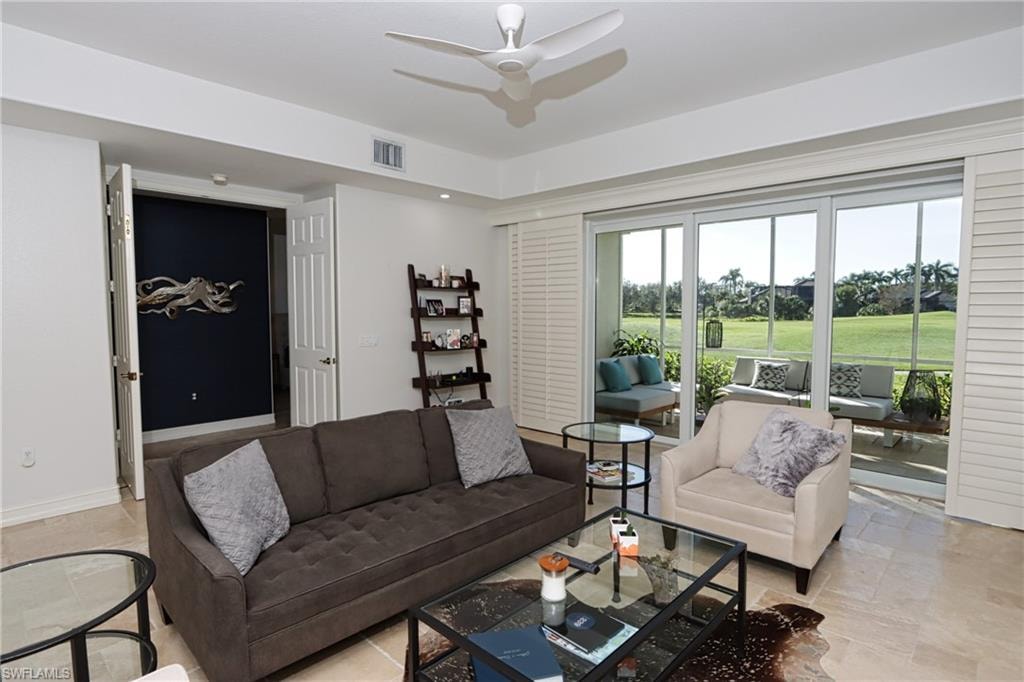 Living room featuring light tile patterned floors, a healthy amount of sunlight, and ceiling fan