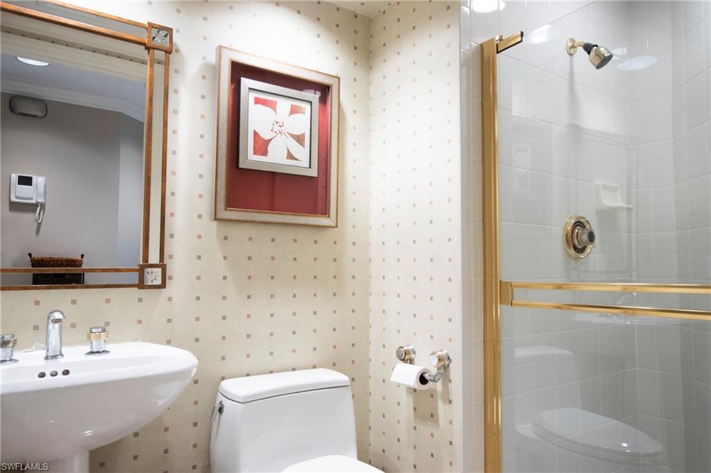 Bathroom featuring sink, an enclosed shower, and toilet