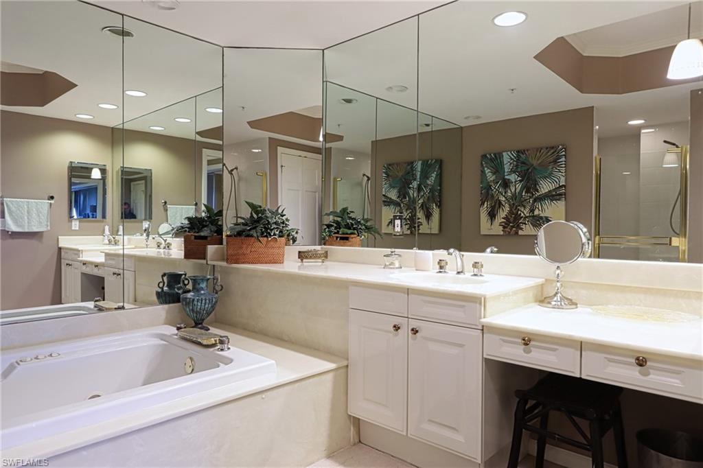 Bathroom featuring vanity with extensive cabinet space and a bath