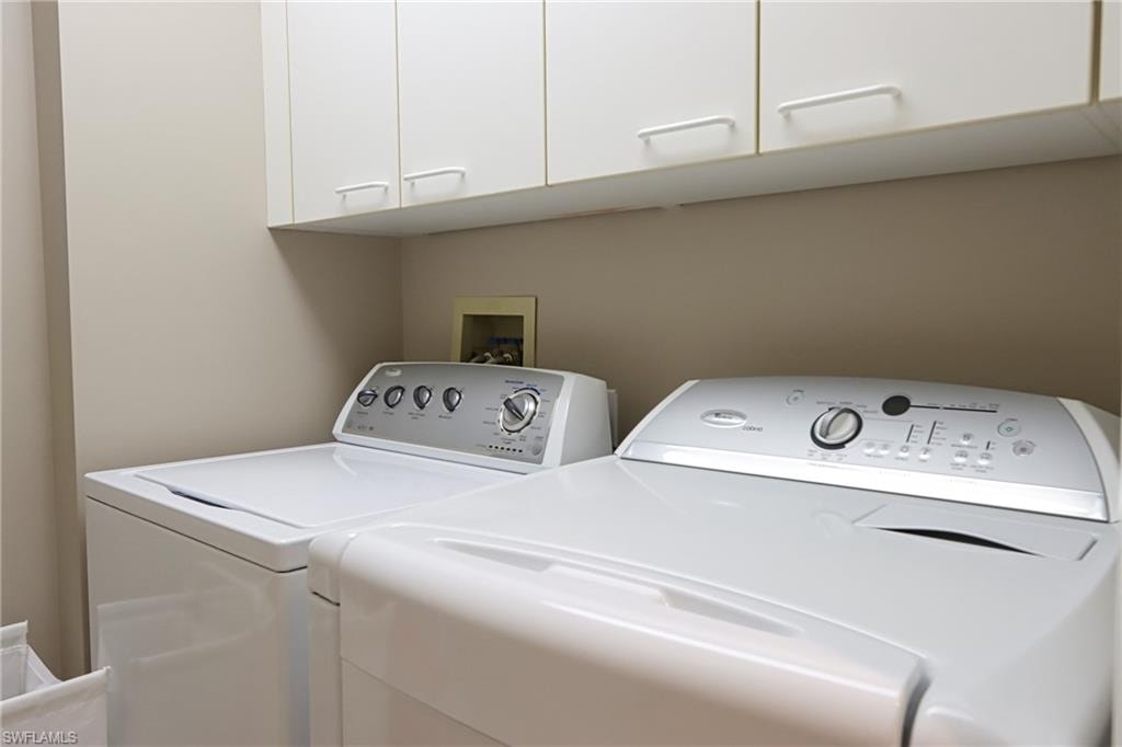 Laundry area with washer and clothes dryer, cabinets, and washer hookup