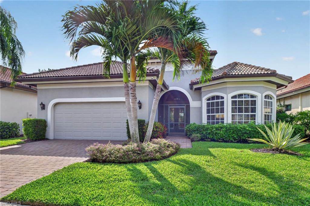 Stucco exterior with a tiled roof, featuring an arched screened entry and a two-car garage