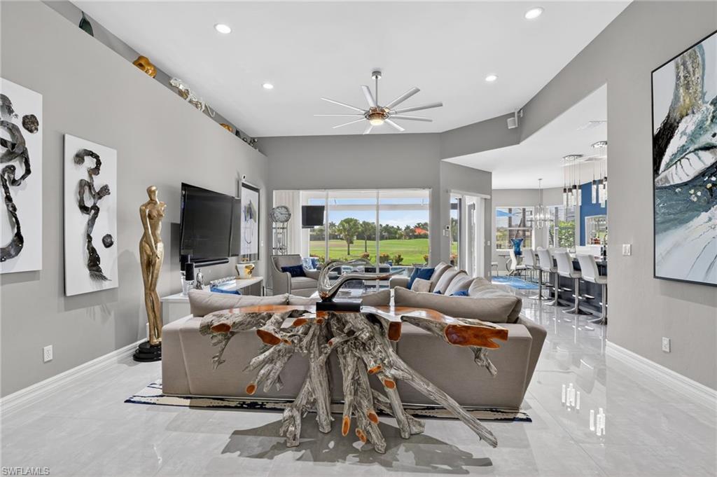 Spacious living area featuring polished tile flooring and volume ceilings
