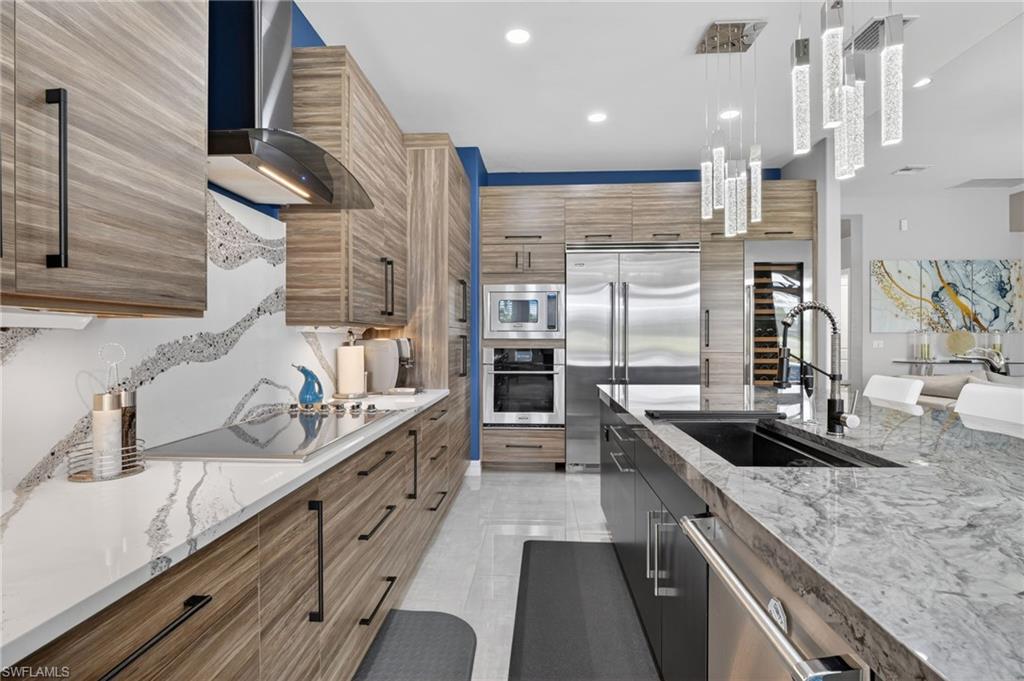 Gourmet kitchen featuring wood-finish cabinetry, superior appliances, a built-in wine refrigerator, beautifully designed and decorated