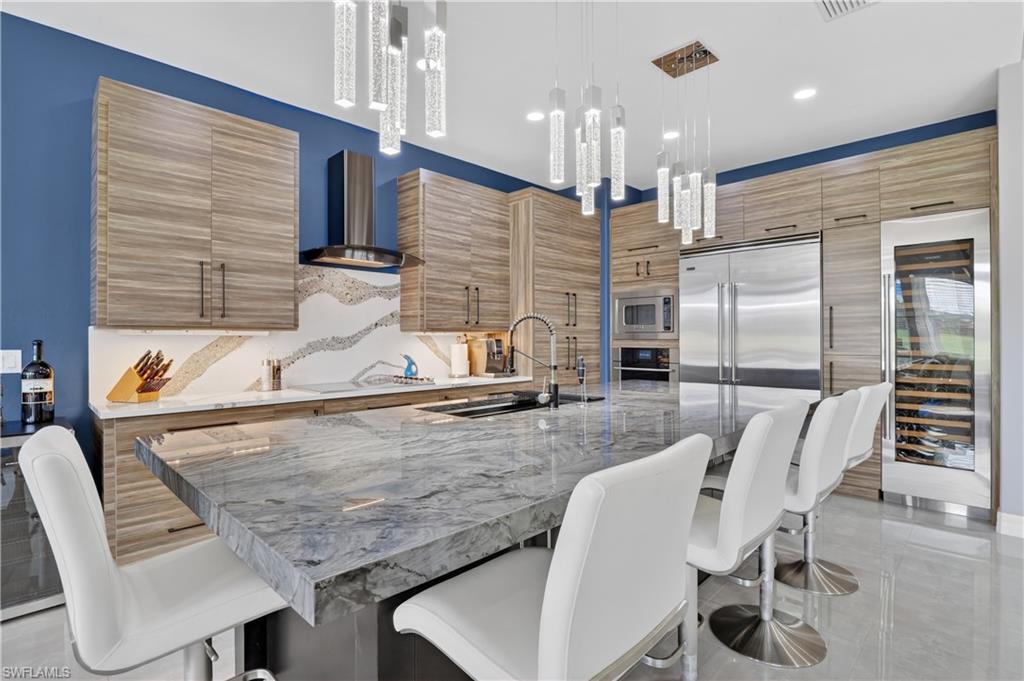 Kitchen featuring an expansive island with a polished stone countertop