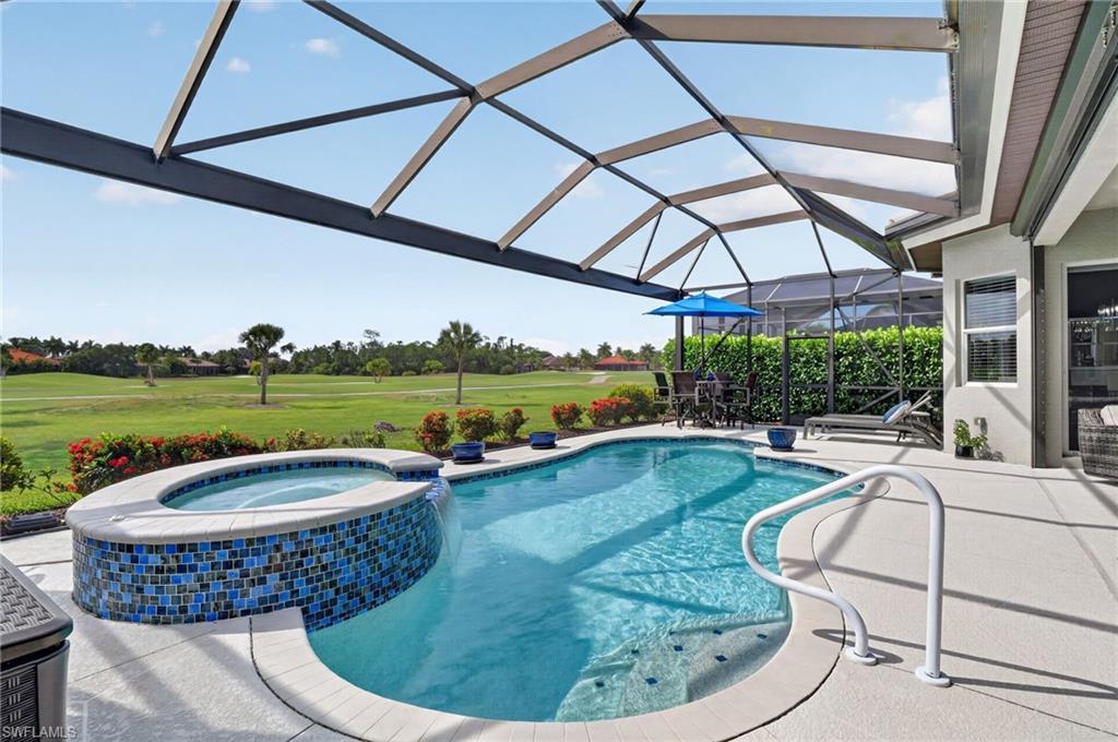 Screened lanai featuring lounging and entertainment area, a freeform pool with integrated spa and mosaic tile accents and breathtaking golf course views