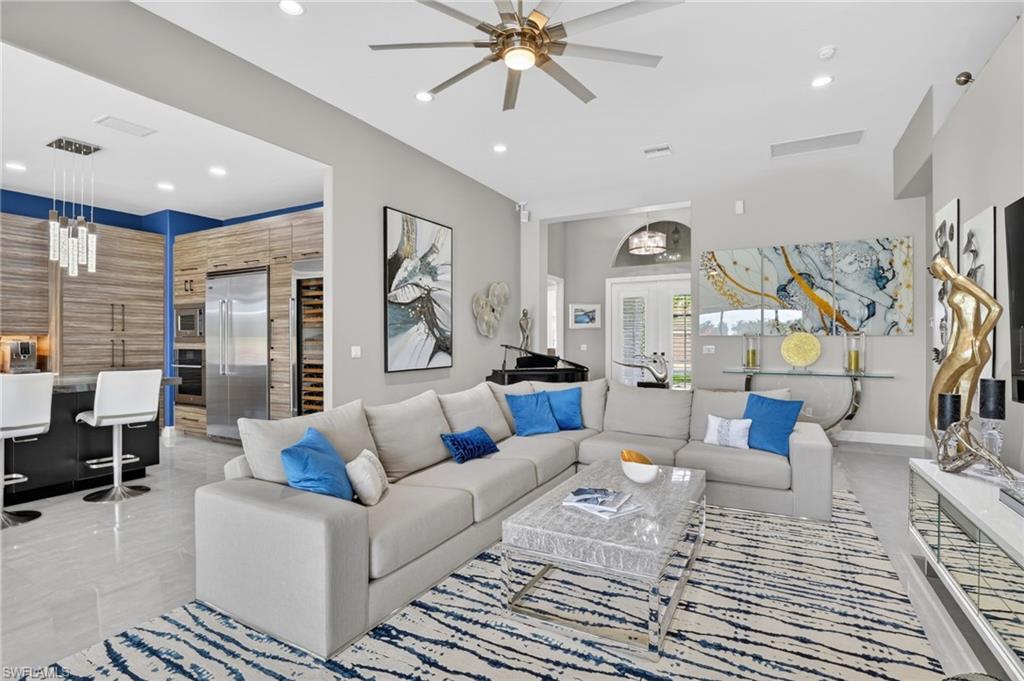 Spacious open-concept living area featuring light tile flooring and a ceiling fan