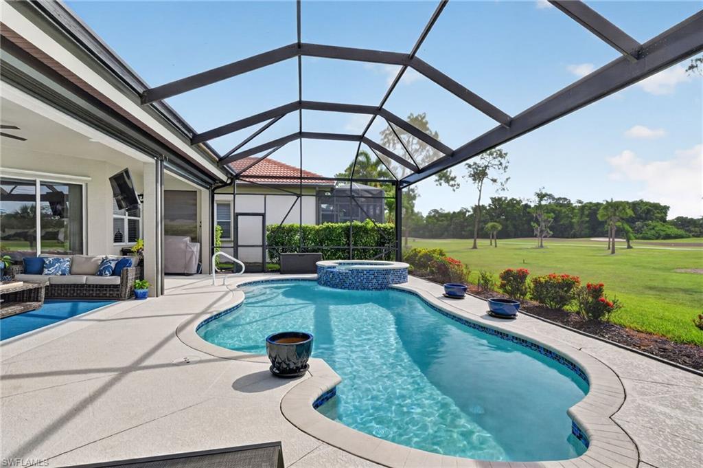 Screened pool deck featuring a  recently resurfaced  freeform swimming pool and integrated spa with updated picture window lanai cage