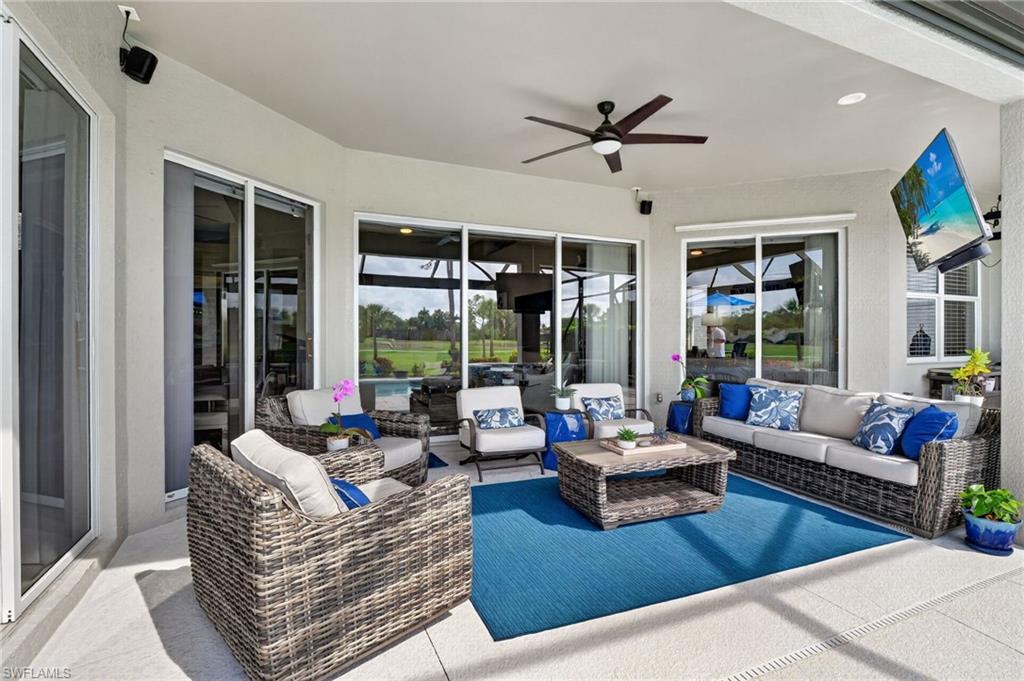 Expansive covered patio featuring plenty of functional space, a ceiling fan, TV, recessed lighting, and multiple sliding glass doors
