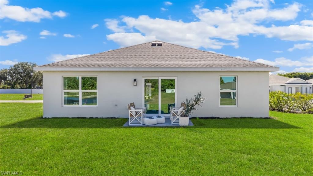 MODEL PHOTO - Rear view of property featuring a shingled roof, a yard, and stucco siding