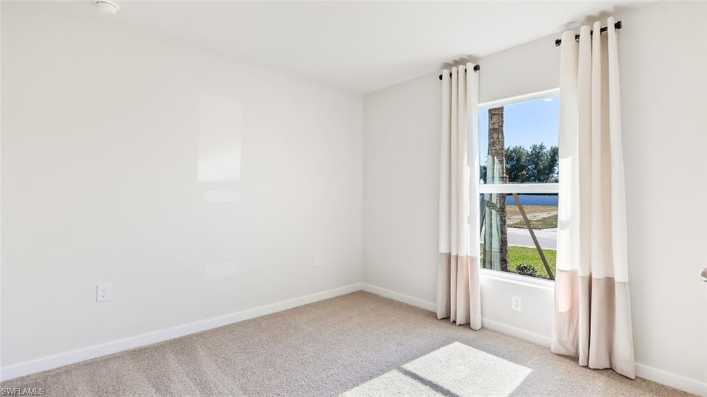 MODEL PHOTO - Spare room with baseboards and carpet floors
