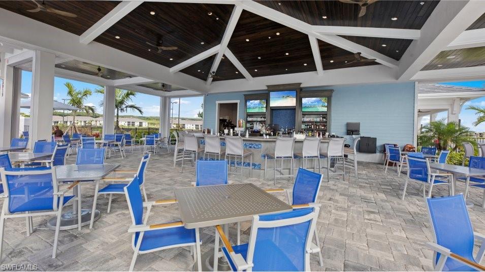View of patio / terrace with a ceiling fan and a bar