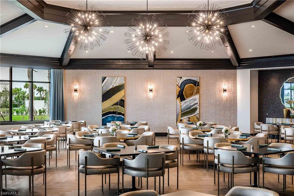 Dining space featuring beam ceiling, wallpapered walls, parquet floors, and suspended lighting