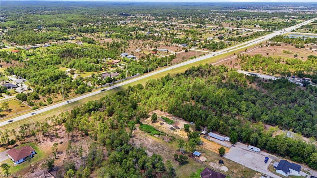 Expansive aerial capturing a vast landscape with dense tree coverage and scattered residential structures