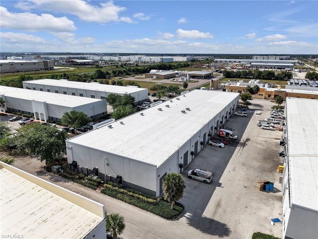 Industrial complex featuring multiple single-story buildings with white roofs and grey siding