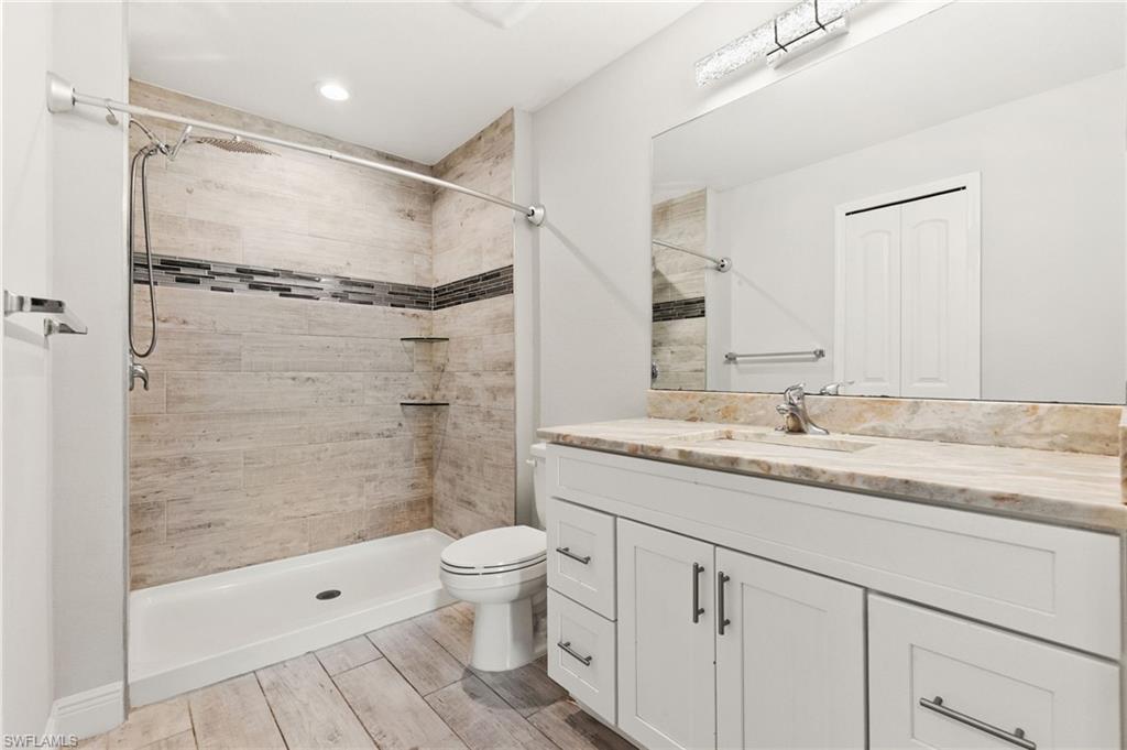 Bathroom featuring a walk-in shower with wood-look tile, decorative accent tile, and two built-in shelves