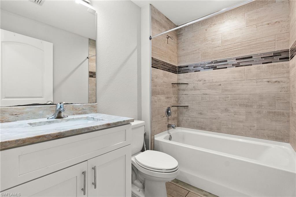 Bathroom featuring a vanity with a light-colored countertop, an undermount sink, and a chrome faucet