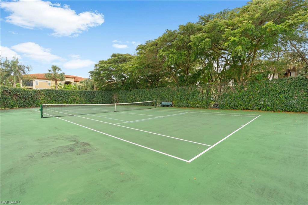 View of tennis court featuring fence
