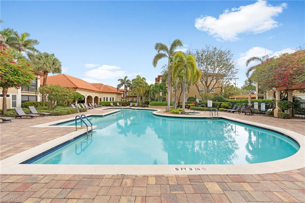 Community pool featuring a patio and fence