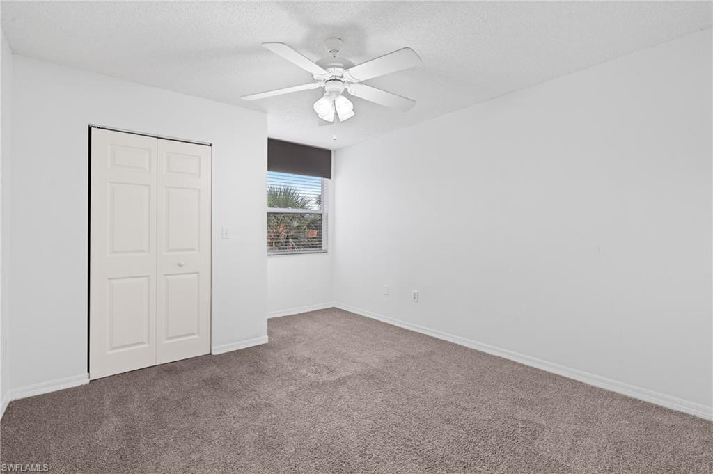 Unfurnished bedroom with baseboards, a ceiling fan, a textured ceiling, carpet flooring, and a closet