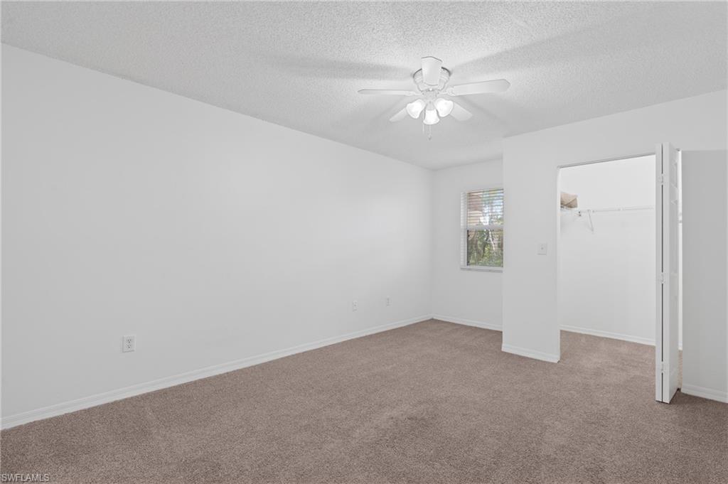 Unfurnished bedroom featuring a textured ceiling, ceiling fan, baseboards, and light colored carpet