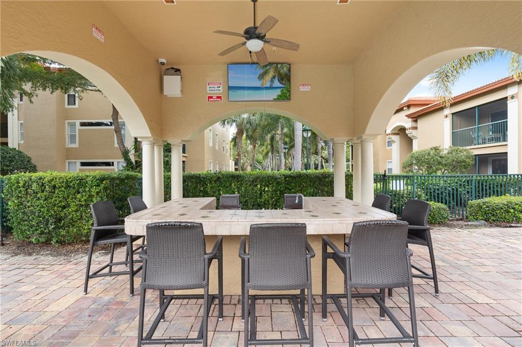 View of patio with ceiling fan, an outdoor bar, and fence